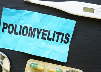 Fondo oscuro con un papel arrugado que dice "POLIOMIELITIS", un termómetro y una caja de cápsulas medicamentosas.
