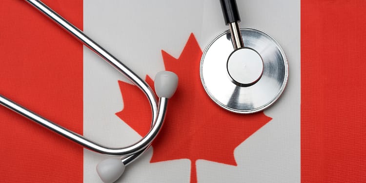 A stethoscope on a Canadian flag, highlighting the red maple leaf in the center.