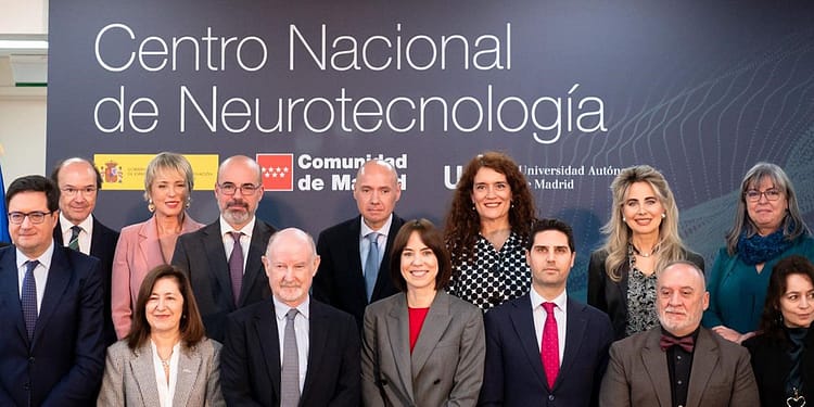 Groups of people posing in front of a background with the text "National Center for Neurotechnology", in a professional environment.